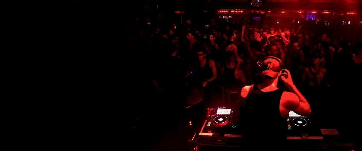 STEV overlooking a red-lit dancefloor